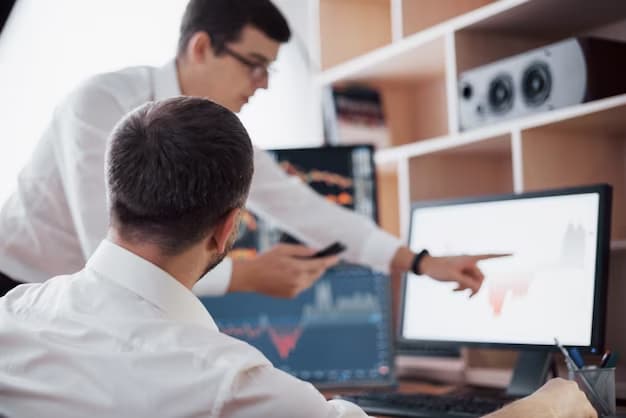 Two men discussing work on the computer