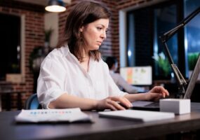 Businesswoman sitting in office workspace and working on computer