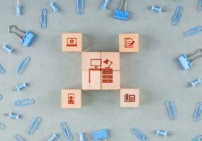 wooden blocks with icons, blue paperclips, and binder clips on the table