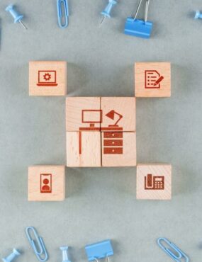 wooden blocks with icons, blue paperclips, and binder clips on the table