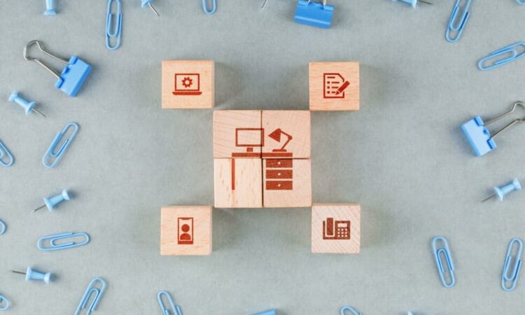 wooden blocks with icons, blue paperclips, and binder clips on the table