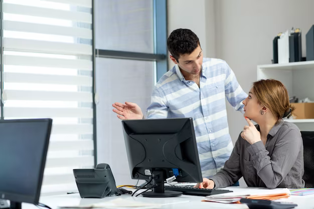 Colleagues in the office are discussing something at the computer