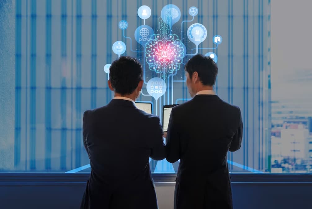 Two executives examine AI and data icons on a screen, implying strategic planning